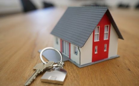 Keys and house model representing real estate investment and property ownership.